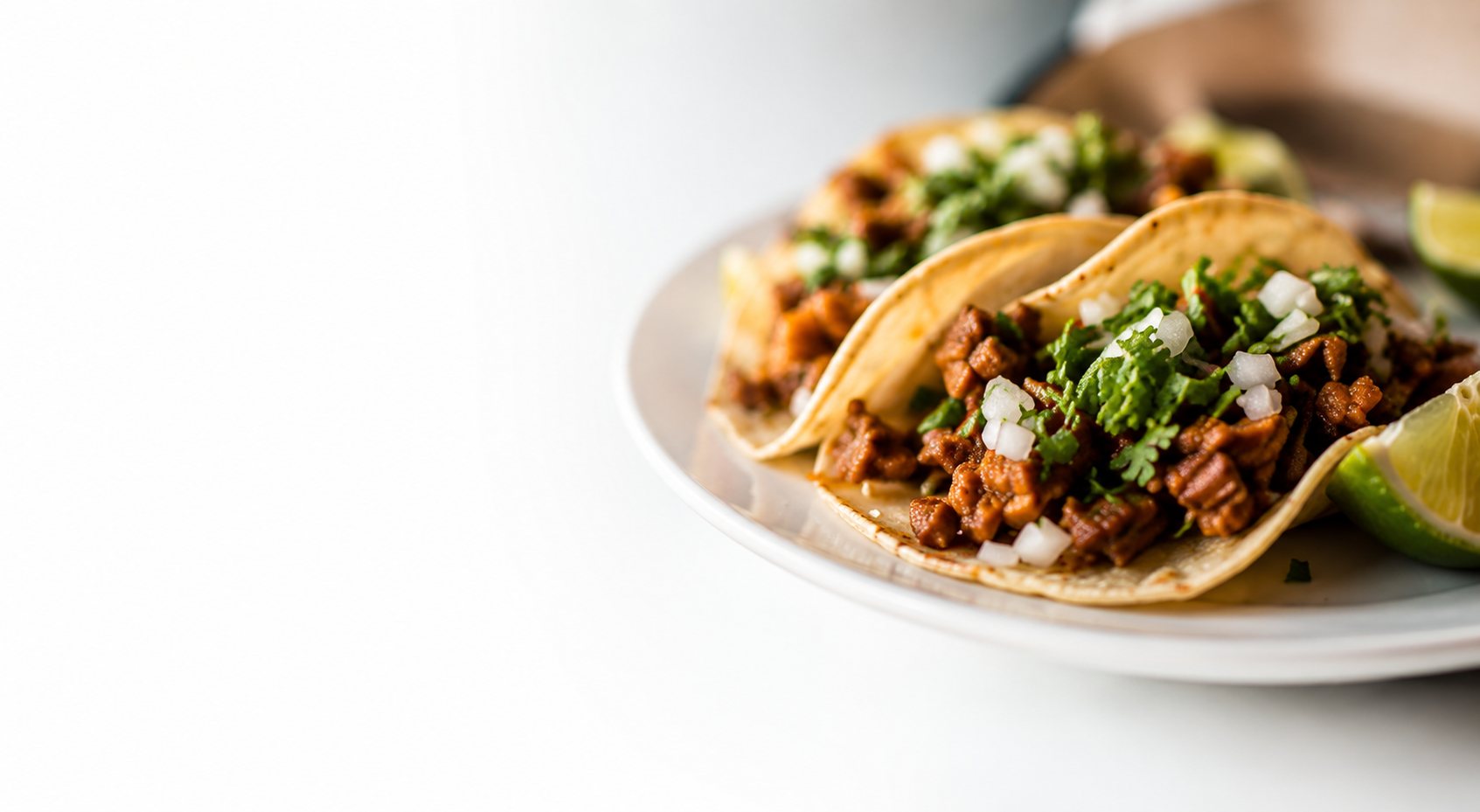 Tacos al pastor on a white plate